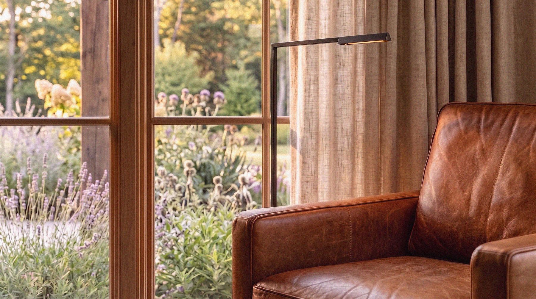 A leather chair by a window, the garden beyond