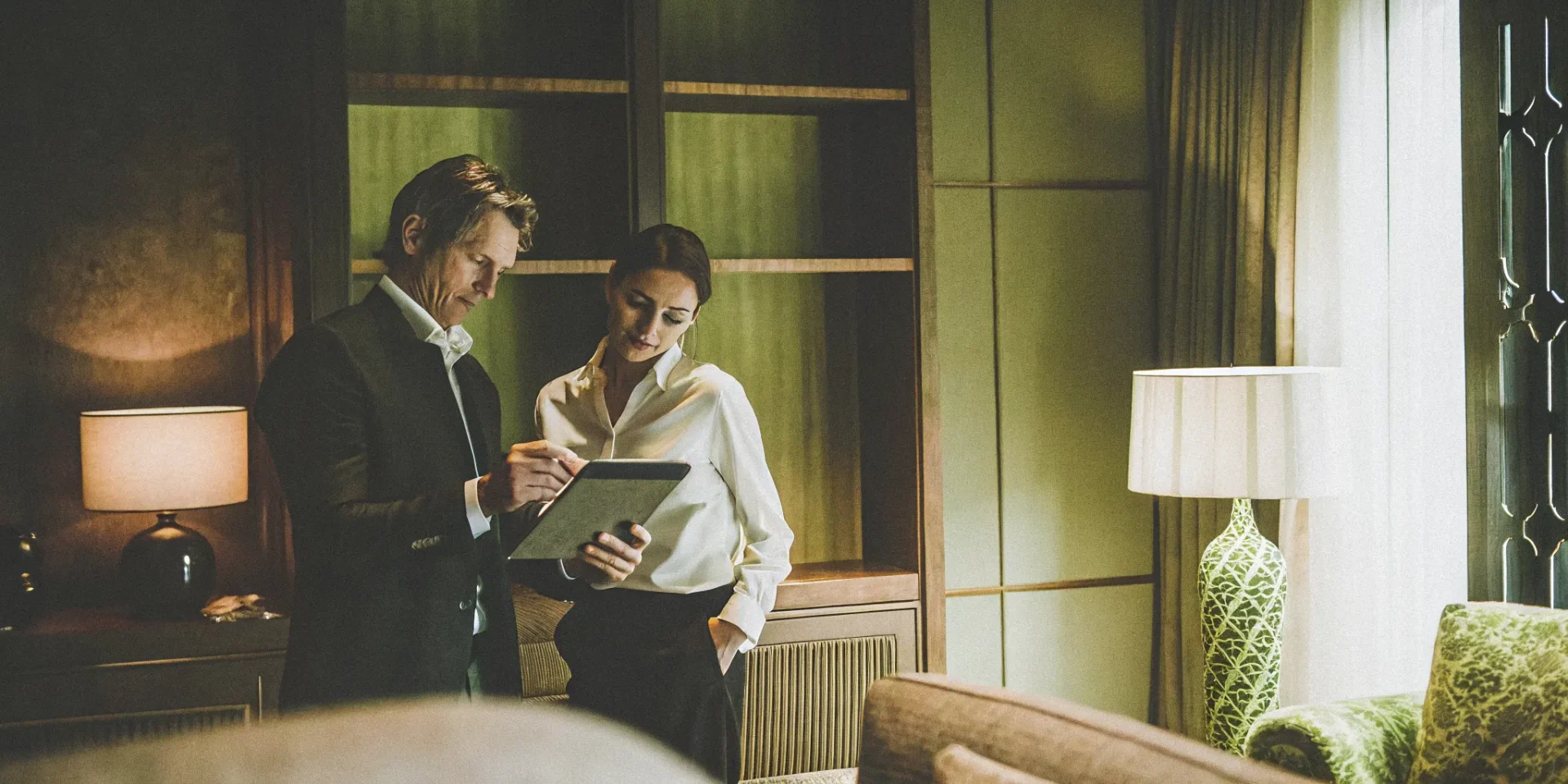 Luxury estate with a house manager reviewing maintenance notes and a household manager coordinating staff operations